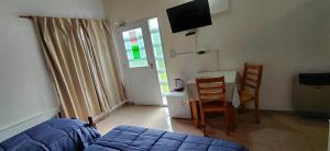 a bedroom with a bed and a table and chairs at La Vilma Hospedaje Familiar in Paganini
