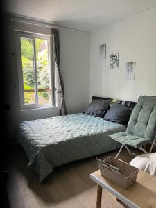 a bedroom with a bed and a couch and a window at charmant studio in Le Bugue