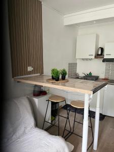 a kitchen with a table and stools in a room at charmant studio in Le Bugue