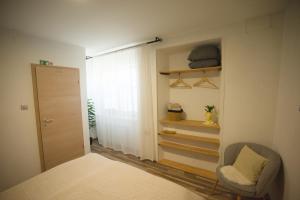 a bedroom with a bed and a chair and a window at FRIZ&FANY Charm House in Postojna