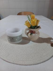 a candle and a vase with flowers on a table at Departamento Quetro in Trevelín +9 photos