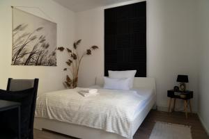 a bedroom with a white bed with a black headboard at Interior Apartments - Service Apartments in Bahnhofsnähe und UNESCO-Bergpark mit Parkplatzmöglichkeit, EBK, kinderfreundlich, Familienzimmer in Kassel