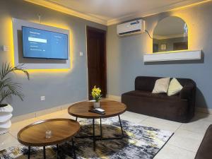 a living room with a couch and a tv on the wall at Max Horizon in Ikeja