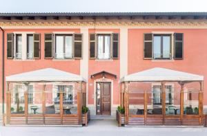 dois gazebos em frente a um edifício cor-de-rosa em Hotel Bacco em Beinette