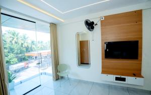 a living room with a flat screen tv on a wall at UK Plaza in Edappāl