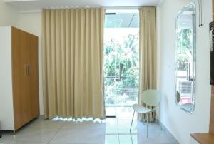 a room with a large window with curtains and a chair at UK Plaza in Edappāl