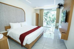 a hotel room with a bed and a television at UK Plaza in Edappāl