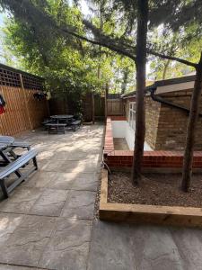 a patio with two picnic tables and a building at 24/7 London Hostel in London