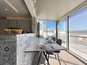 a dining room with a table and a balcony at Pergola Penthouse Xaghra in Xagħra