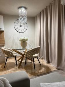 a dining room with a table and two chairs and a clock at Rosabell in Imotski