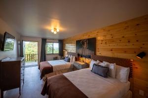 a hotel room with two beds and a balcony at The Woodsman Lodge in Eureka Springs +138 photos