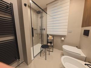 a bathroom with a toilet and a glass shower at Loft 26 Apartment in Caltanissetta