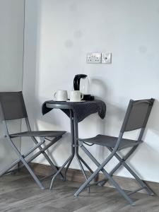 a table with two chairs and a coffee maker on it at شالية الشفق in Al ‘Aqar
