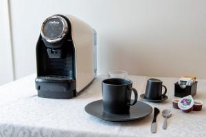 a table with a coffee maker and a coffee cup at Alba sul Mare Guest House in Massignano