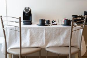 a table with two chairs with a white table cloth at Alba sul Mare Guest House in Massignano +37 photos