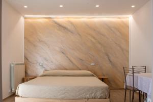 a bed in a room with a wooden wall at Alba sul Mare Guest House in Massignano