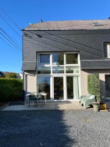 a house with a patio with a table and chairs at The 8th in Léglise