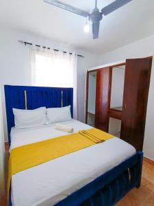 a blue and yellow bed in a room at Bella Accomodations, Mombasa in Bamburi