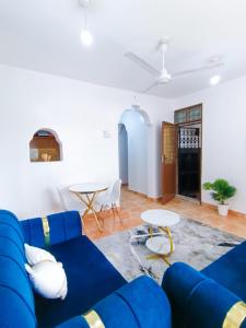 a living room with a blue couch and a table at Bella Accomodations, Mombasa in Bamburi