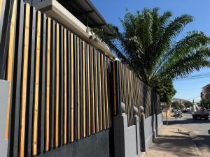 a fence next to a street with a palm tree at Angel Guest House in Maputo +1 photo