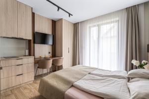 a bedroom with a bed and a desk and a television at Willa Horyzont in Hel