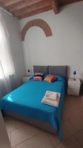 a bedroom with a blue bed with two pillows at Dimora toscana in Santa Maria del Giudice