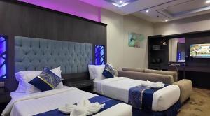 a hotel room with two beds and a television at فندق ان فيولا in Jazan