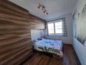 a bedroom with a bed and a large wooden wall at Apartament Rekiny na Wakacjach - Aquapark Reda 200m - Prywatny Parking in Reda