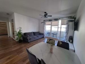 a living room with a table and a couch at Apartament Rekiny na Wakacjach - Aquapark Reda 200m - Prywatny Parking in Reda