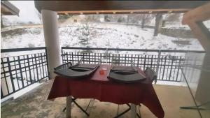 a table on a balcony in the snow at Cocon cosy et spa au Château des Magnans Jausiers in Jausiers +15 photos