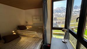 a room with two beds and a window with mountains at Exception Ski Émerveillement in Pas de la Casa