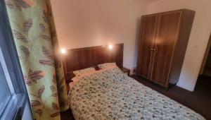 a bedroom with a bed and a wooden cabinet at Cocon cosy et spa au Château des Magnans Jausiers in Jausiers