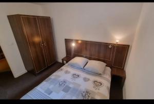 a bedroom with a bed with a wooden headboard at Cocon cosy et spa au Château des Magnans Jausiers in Jausiers
