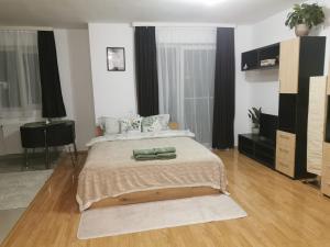 a bedroom with a bed with two green pillows on it at Flower Apartment in Floreşti