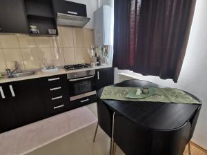 a small kitchen with a black table and a sink at Flower Apartment in Floreşti