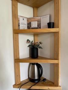 a wooden shelf with a tea kettle on it at Golden hour tiny house in Arusha