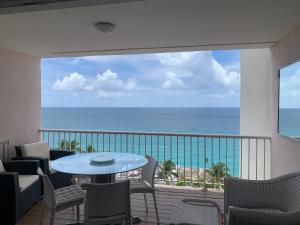 a balcony with a table and chairs and the ocean at Seabreeze suite in Cupe Coy