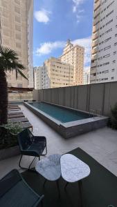 a rooftop patio with two chairs and a swimming pool at Premium Suite - Perdizes - Luxury & Panoramic View in São Paulo