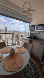 a room with a table and a balcony with a view at Premium Suite - Perdizes - Luxury & Panoramic View in São Paulo