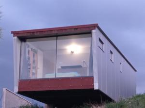 a house with a large window on the side of it at solar eclipse house in Husillos +3 photos