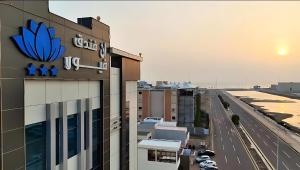 a building with a sign on it next to a road at فندق ان فيولا in Jazan