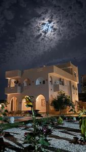 a large building with the moon in the sky at Magic Garden House in Luxor