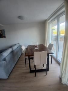 a dining room with a table and a couch at Apartmaji pri Pinku in Breginj