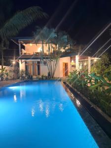 a blue swimming pool in front of a house at night at All View Resort in Tangalle +89 photos