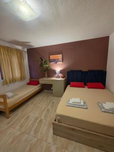 a room with two beds and a table and a desk at Apartmani Tina in Sutomore