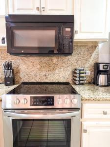a microwave above a stove in a kitchen at Sandy Beach Princesa D101 Ocean Front Resort in Puerto Peñasco