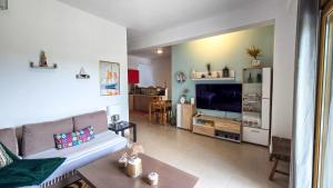 a living room with a couch and a tv at Angelo’s Elegant Summer House in Possidi