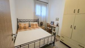 a small bedroom with a bed and a desk at Angelo’s Elegant Summer House in Possidi