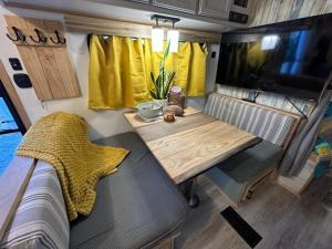 a dining table in a trailer with a tv at SpongeBob SquarePants on the River in Bullhead City