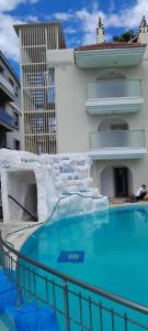 a swimming pool with a water slide in front of a building at Rayon Apart hotel in Marmaris